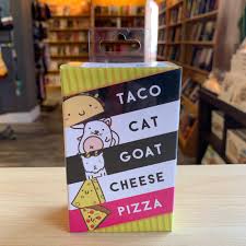 Independent local board game store interior with shelves of popular party games including Taco Cat Goat Cheese Pizza